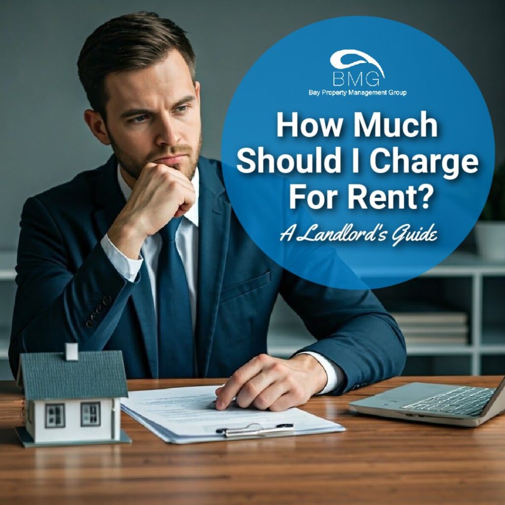 A man in a suit sits at a desk with a model house, paperwork, and a laptop, contemplating rental pricing. A circular graphic reads, "How Much Should I Charge For Rent? A Landlord's Guide," with the Bay Property Management Group logo.