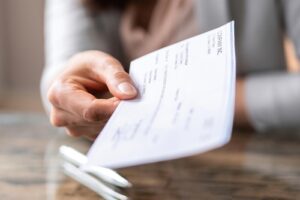 Hand holding a paycheck. 