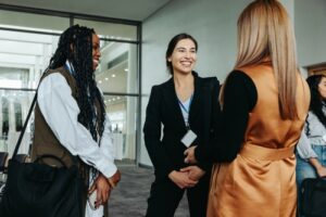 Three women talk about their housing situations in a friendly manner.